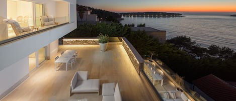 Ein Blick auf die Außenterrasse mit Liegestühlen und Sofas und ein Blick auf das Meer in der Luxusvilla zur Miete Primosten Glamour in Primosten