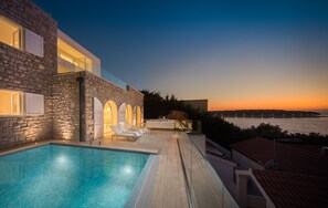 Private outdoor pool surrounded by deck chairs on the outdoor terrace with a view of the sea in the luxury Dalmatia holiday villa Primosten Glamour