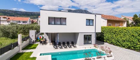 View of Croatia luxury villa Split Lady 2 with a green lawn and a private pool in Kastel Kambelovac