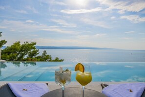 Blick auf den privaten beheizten Pool und das Meer von der Außenterrasse mit Sonnenliege in der Kroatien luxuriösen Villa Glorious Brela in Brela