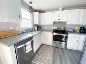 Fully equipped kitchen with electric range, microwave and stainless steel refrigerator