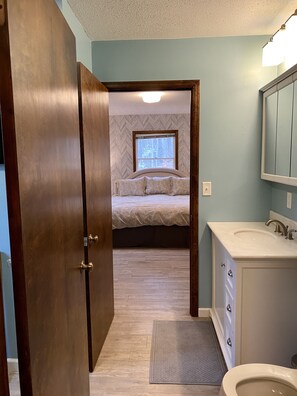 Bathroom with marble topped vanity & double door entrance to master bedroom