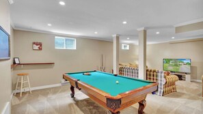 comfortable sofas, pool table and big screen tv in games room 1
