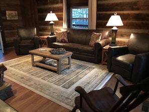 Original log cabin living room with wood burning fireplace