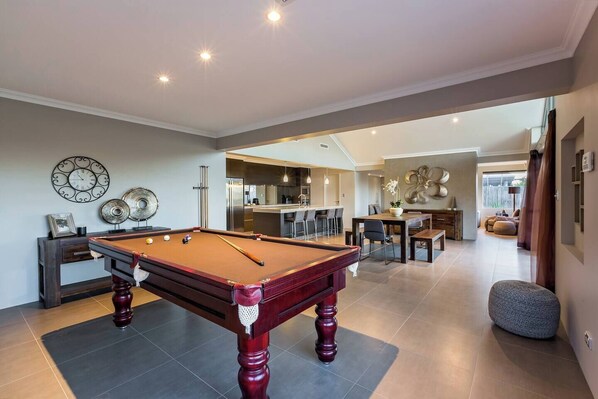 A stylish and spacious entertainment zone with a full-size pool table, perfect for some friendly competition.