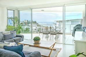 Living area overlooking Kings Beach through a floor to ceiling window.