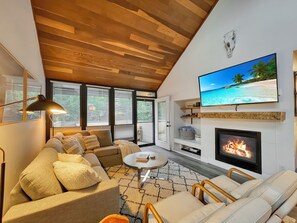 The cozy living room features a fireplace, a smart TV,  and a gas fireplace. It's a great place to enjoy time with family and friends!