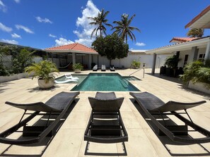 Enjoy the pool & palm trees view from a comfortable sunbed