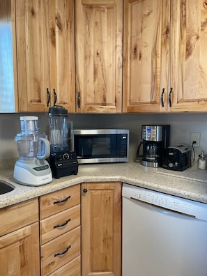 A few appliances in the kitchen including a Vitamin blender.