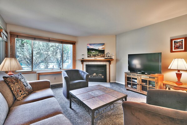 Living room features brown barrel chairs, and a comfortable fabric sofa sleeper