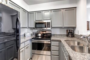 Snow Flower 12's kitchen has light grey cabinetry, stainless steel appliances and crisp white walls.