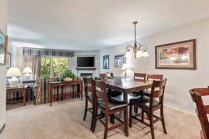 Snow Flower 135's dining area with a wood table, 6 dining chairs, and chandelier.