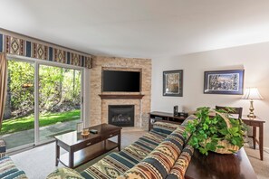 Snow Flower 135's living room with southwestern upholstered couch and gas fireplace with flat screen TV mounted above.