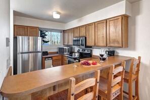 The well-equipped kitchen offers a breakfast bar and stainless steel appliances.