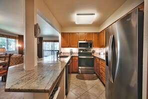 Kitchen with french door stainless steel refrigerator, chrome stove and granite countertops