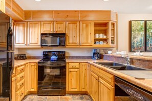 Snow Flower 156 has a well equipped kitchen with classic wood cabinets and black appliances.