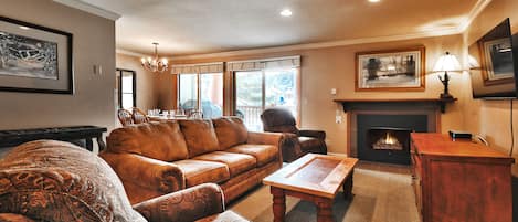 The living room features a comfortable brown leather couch, and two recliners