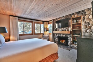 Main bedroom features a wood-burning fireplace with rock surround