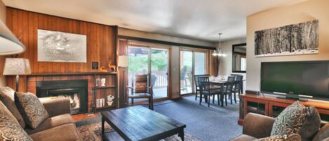 Living room features a comfortable fabric couch and love seat with a large flat-screen TV
