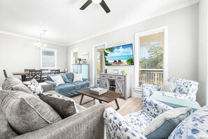 Open floor plan in this 2nd floor main living area with a new sleeper sofa and a 65" smart tv.  Large collection of DVDs for the DVD player!  There's also a balcony with seating for morning coffee or evening cocktails just off the living room overlooking the community.