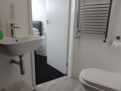 Private En Suite Bathroom with toilet, sink and electric shower. 