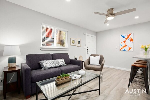 Open concept living room and kitchen with sleeper sofa and smart TV