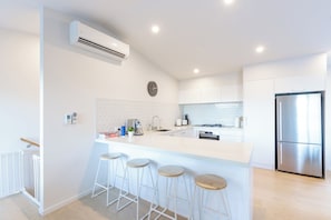 Kitchen with lots of bench space for cooking and breakfast bar; forest views