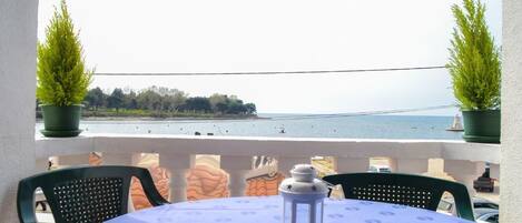 La terrasse équipée avec table et 4 chaises, 2 transats et une vue magnifique sur la mer