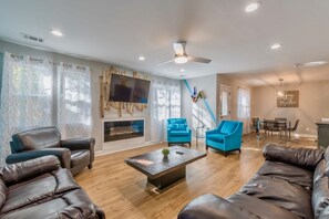 The spacious living room has a modern design and features a fireplace.