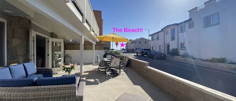 Stretch out on the large patio! Patio table seats six and L-shaped couch also seats six!  Two houses to the beach!