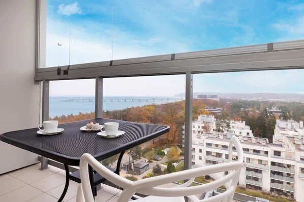 Furnished balcony with green surroundings. 