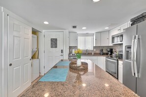 Entrance door, complete kitchen and Washer/Dryer combo at the condo