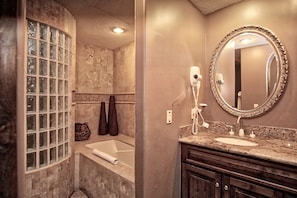 Bathroom with glass block shower stall, separate tub, and vanity area.