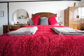 Bedroom Retreat: Vibrant red bedding and plush pillows create an inviting escape for relaxation!