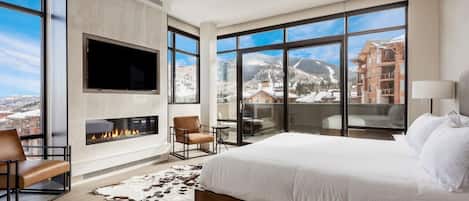 Exquisite main bedroom suite with private patio, floor to ceiling windows and quartz feature fireplace wall with large screen TV