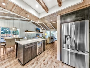 The kitchen is complete with stainless steel appliances, including a wine fridge