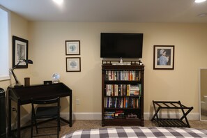 Wall mounted smart TV and a wide variety of books for your entertainment.