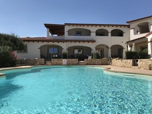 Vista frontale con la piscina centrale. Appartamento al 1° piano con terrazza.