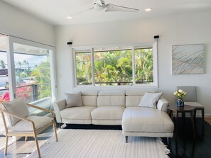 Spacious living room with leather couch and newly-installed split AC 
