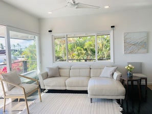 Spacious living room with leather couch and newly-installed split AC 
