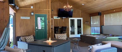 Covered deck, hot tub, fire table, lounge, speakers, heaters, & TV for guests.
