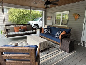 Covered patio with custom made furniture along with  fire table and smart tv