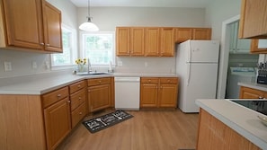 LVP flooring and kitchen featuring Refrigerator, dishwasher, and all the cooking/baking supplies needed 