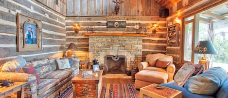 As you enter the living room is to the right and features a stone fire place