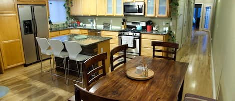 Open and fully furnished kitchen w/ bar/island seating and 6 person dining table