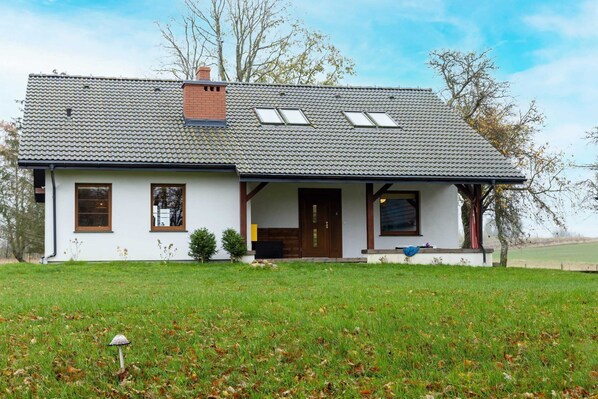 A white house with grey tiles and a veranda invites you to linger in pleasant surroundings.