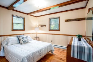 A cozy bedroom with a queen bed and AC