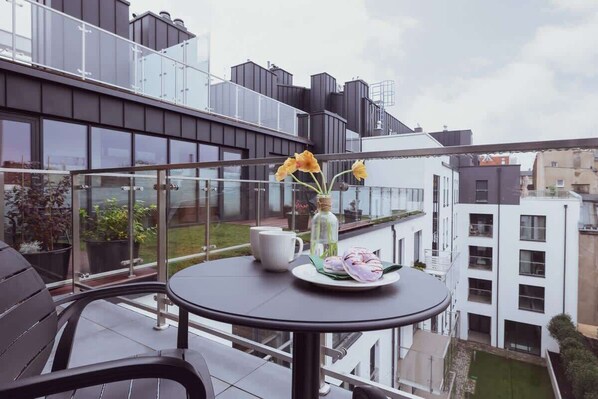 Furnished balcony with green surroundings. 