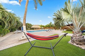 Escape to tranquility in your own backyard oasis, complete with a serene hammock by the poolside.
