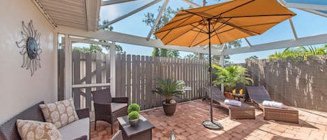 PV129 - The covered lanai and screened back patio offer complete privacy and are great for lounging and entertaining and feature a BBQ, a dining area, a seating area and lounge chairs!